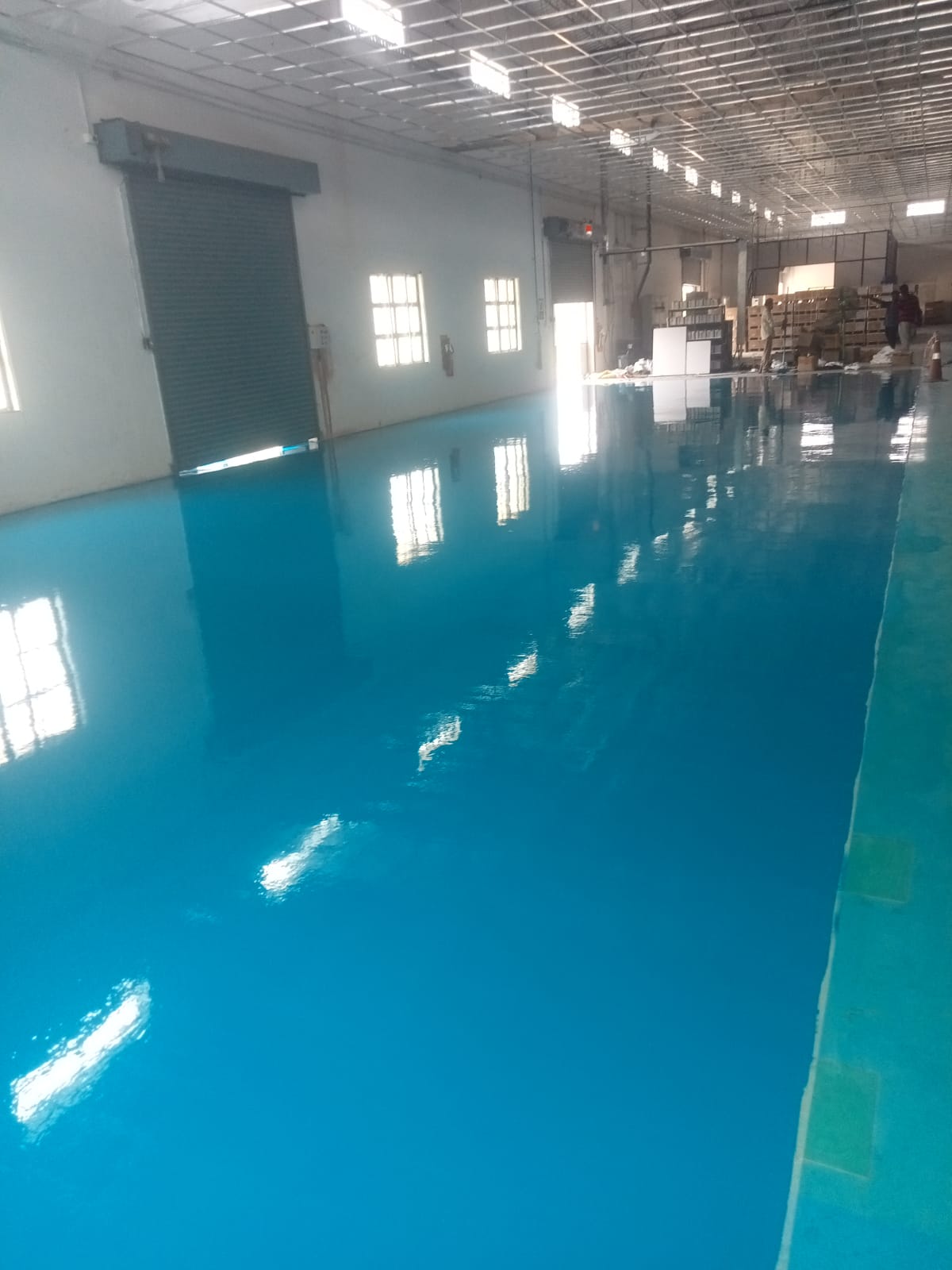 High gloss blue epoxy floor in a large manufacturing hall