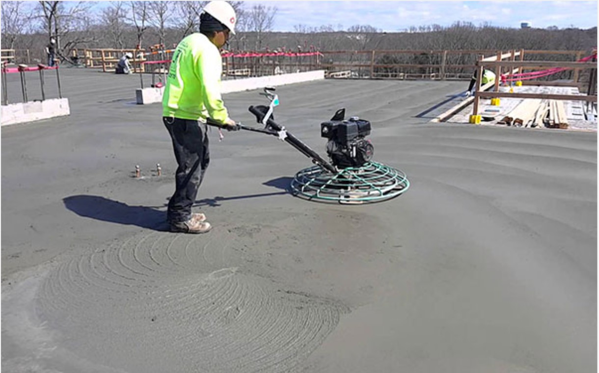 Vacuum dewatered flooring being laid and power trowelled on site